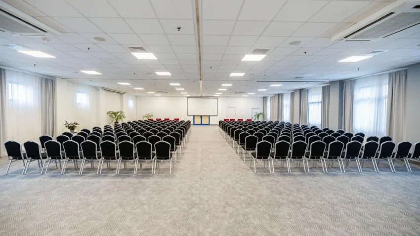 Sala konferencyjna w Hotelu 500 Stryków z ustawieniem teatralnym, ekranem projekcyjnym i miejscami dla dużej grupy uczestników.